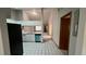 A view of the modern kitchen with white cabinetry, stainless steel appliances, and black and white tiled flooring at 3550 Forest Branch Dr # A, Port Orange, FL 32129