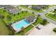 Aerial view of a community pool area featuring a pool, clubhouse, lounge chairs, and landscaping at 3565 Fernanda Dr, Deltona, FL 32738