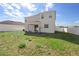 Large backyard featuring green grass, white fence, and the home's exterior at 3565 Fernanda Dr, Deltona, FL 32738
