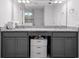 Bathroom vanity with double sinks, gray cabinets, granite counters, and a built-in storage area at 3565 Fernanda Dr, Deltona, FL 32738