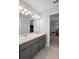 Modern bathroom with dual sinks, gray cabinets, and a large mirror above the vanity at 3565 Fernanda Dr, Deltona, FL 32738