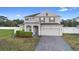Charming two-story home with a well-maintained lawn, brick driveway, and attached two-car garage at 3565 Fernanda Dr, Deltona, FL 32738