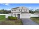 Charming two-story home with landscaped yard, brick driveway, and attached two-car garage at 3565 Fernanda Dr, Deltona, FL 32738