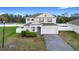 Attractive two-story house featuring a brick driveway, manicured landscaping, and an attached garage at 3565 Fernanda Dr, Deltona, FL 32738
