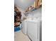 Bright laundry room with white washer and dryer, storage shelves, and tiled flooring at 3565 Fernanda Dr, Deltona, FL 32738