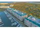 Stunning aerial view of condominiums, marina, and lush landscape offering a serene waterfront living experience at 4626 Harbour Village Blvd # 3302, Ponce Inlet, FL 32127