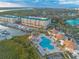 Aerial view of waterfront condos, a marina, and a pool area with cabanas, offering luxury waterfront living at 4626 Harbour Village Blvd # 3302, Ponce Inlet, FL 32127