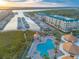 Aerial view featuring a marina, a swimming pool with cabanas, and condo buildings on the waterfront at 4626 Harbour Village Blvd # 3302, Ponce Inlet, FL 32127