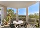 Relaxing covered balcony with a table and seating, offering views of the nearby landscape at 4626 Harbour Village Blvd # 3302, Ponce Inlet, FL 32127
