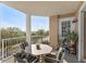Relaxing covered balcony with a table and seating, offering views of the nearby landscape at 4626 Harbour Village Blvd # 3302, Ponce Inlet, FL 32127