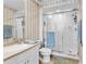 Clean bathroom featuring a glass-enclosed shower, vanity with sink, and decorative wallpaper at 4626 Harbour Village Blvd # 3302, Ponce Inlet, FL 32127