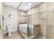 Bathroom featuring a corner tub with a large, glass-enclosed shower with stylish neutral tile at 4626 Harbour Village Blvd # 3302, Ponce Inlet, FL 32127