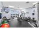 Modern gym with an ocean view, various weight machines, television, and an exit to a patio at 4626 Harbour Village Blvd # 3302, Ponce Inlet, FL 32127