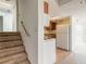 Galley kitchen next to carpeted stairs features white appliances and wood cabinets at 4734 S Atlantic Ave, Ponce Inlet, FL 32127