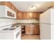 Kitchen features wood cabinetry, white appliances, and tile flooring at 4734 S Atlantic Ave, Ponce Inlet, FL 32127