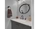 Elegant half bathroom with a marble countertop, a round mirror, a mounted towel, and modern fixtures at 510 Silvergate Loop, Lake Mary, FL 32746