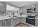 Modern kitchen featuring stainless steel appliances, white countertops, grey cabinets, and wood look flooring at 510 Silvergate Loop, Lake Mary, FL 32746