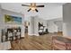 Open living area with a ceiling fan, wood floors, television, and exercise equipment at 510 Silvergate Loop, Lake Mary, FL 32746