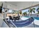 Relaxing covered patio with dining set, hammock, and string lights overlooking the beautiful pool area at 510 Silvergate Loop, Lake Mary, FL 32746
