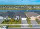 An aerial view of a landscaped home with a manicured lawn overlooking a tranquil lake with fountain at 6271 W Fallsgrove Ln, Port Orange, FL 32128