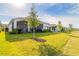 Green backyard lawn with a view of the covered patio and outdoor seating at 6271 W Fallsgrove Ln, Port Orange, FL 32128