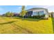 View of the home from the backyard and a green lawn at 6271 W Fallsgrove Ln, Port Orange, FL 32128