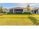 Green backyard lawn with a view of the covered patio and outdoor seating area at 6271 W Fallsgrove Ln, Port Orange, FL 32128