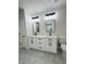 Bathroom featuring dual sinks, modern fixtures, and stylish hexagon tile flooring at 679 Rhodes Dr, Deland, FL 32720
