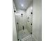 Contemporary shower with white tile surround, glass enclosure, and matte black hardware at 679 Rhodes Dr, Deland, FL 32720