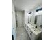 Modern bathroom featuring double sinks, marble countertops, and hexagonal tile floors at 679 Rhodes Dr, Deland, FL 32720