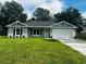 Charming single-story home featuring a well-manicured lawn, attached two-car garage and inviting front entrance at 679 Rhodes Dr, Deland, FL 32720