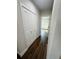 Hallway with a closet and hardwood floors leading to a bedroom at 679 Rhodes Dr, Deland, FL 32720