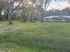 Large yard and back view of single-story home with metal roof at 7108 East Rd, Lakeland, FL 33809