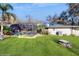Manicured lawn with mature trees, landscaping, screened-in pool, and patio at 7108 East Rd, Lakeland, FL 33809