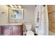Bathroom with vanity, mirror, toilet and shower with decorative curtain at 7108 East Rd, Lakeland, FL 33809