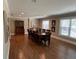 A dining room with a wooden table, chairs, wood floors, and large windows at 7108 East Rd, Lakeland, FL 33809