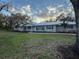 A bright single story house, with metal roof, surrounded by a lush lawn and trees at 7108 East Rd, Lakeland, FL 33809