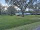 Single story home with a light-colored exterior, metal roof, and expansive green lawn at 7108 East Rd, Lakeland, FL 33809