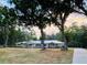 A bright single story home, with metal roof, surrounded by a lush lawn and trees at 7108 East Rd, Lakeland, FL 33809