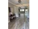 Inviting foyer featuring wood-look tile floors, a stylish console table, and an open view to the living room at 7108 East Rd, Lakeland, FL 33809