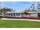 Charming one-story home with well-manicured lawn, walkway, and lush landscaping at 7108 East Rd, Lakeland, FL 33809