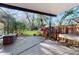 Covered patio with wood floor and view of fenced-in yard and tropical foliage at 7108 East Rd, Lakeland, FL 33809