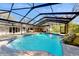 Enclosed pool with large patio area and beautifully landscaped rock waterfall feature at 7108 East Rd, Lakeland, FL 33809