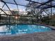 Beautiful swimming pool with screened enclosure and lush landscaping at 7108 East Rd, Lakeland, FL 33809