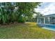 Lush backyard with a sunroom, perfect for enjoying the outdoors in comfort and privacy at 72 Rockefeller Dr, Ormond Beach, FL 32176