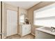 Cozy bathroom featuring a vanity with marble countertop, decorative mirror, and natural light from a window at 72 Rockefeller Dr, Ormond Beach, FL 32176