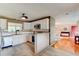Open kitchen boasts white cabinets, stainless appliances, peninsula bar, and seamless flow to dining area at 72 Rockefeller Dr, Ormond Beach, FL 32176