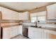 Bright kitchen with white cabinetry, stainless steel appliances, double basin sink, and granite countertops at 72 Rockefeller Dr, Ormond Beach, FL 32176