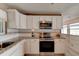 Modern kitchen features white cabinets, granite countertops, stainless steel appliances, and tile backsplash at 72 Rockefeller Dr, Ormond Beach, FL 32176