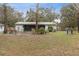 Backyard featuring a screened-in porch, lush greenery, and a spacious yard, ideal for outdoor enjoyment at 749 Cassadaga Rd, Lake Helen, FL 32744